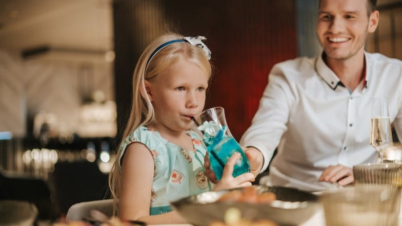 A child at the table drinking a children's cocktail